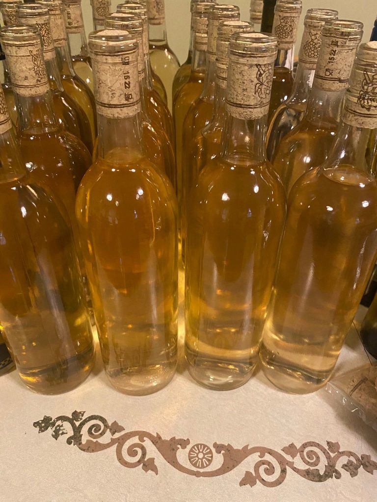 Homemade wine bottles produced at MakeWineLab using traditional home winemaking techniques.